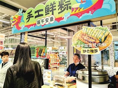 端午将至，刚开业的西北旺万象汇吸引大量市民采购节日用品。图为顾客在盒马鲜生选购手工鲜粽。