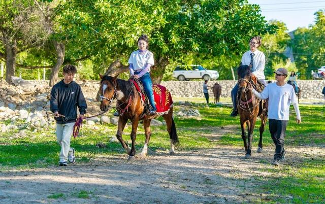 图为”00后“哈萨克族小伙儿阿克居力·教德别克带游客骑马观光（左一）