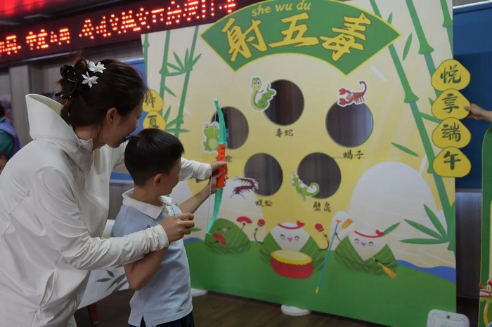 ▲6月6日，安徽省合肥市某社区，小朋友在参加端午习俗“射五毒”游戏。图片来源：IC photo