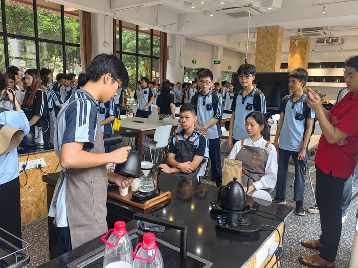 同学们观看一职校学生冲泡咖啡。