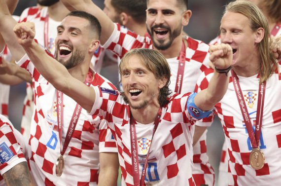 2022年12月17日，克罗地亚队球员莫德里奇（中）在卡塔尔世界杯颁奖仪式上庆祝。新华社记者 贾浩成 摄