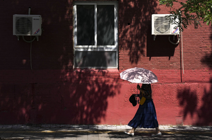 2024年6月12日，北京海淀区莲玉桥，持续高温天气下，市民顶烈日出行。视觉中国供图