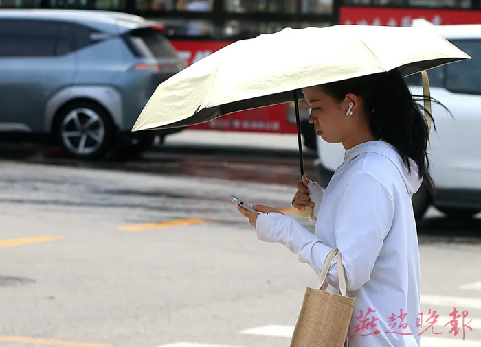 高温天气，市民身穿防晒服、打遮阳伞来抵挡阳光。（资料图）燕赵晚报记者 张海强 摄