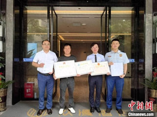 东安县住建、消防等职能部门上门为欢漫酒店送工程竣工验收备案表和消防验收意见书。 严洁 摄