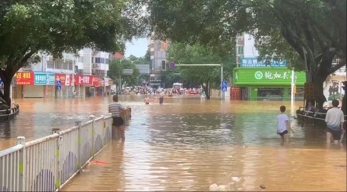 桂林市七星区，市民们蹚在齐腰的积水中前行。受访者供图