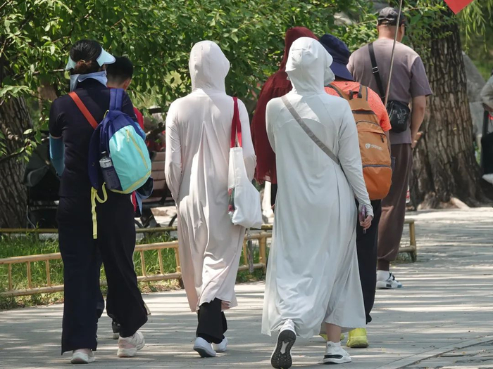 2024年6月3日，北京迎晴热暴晒天气，图为穿着防晒衣的游客 图片来源：视觉中国