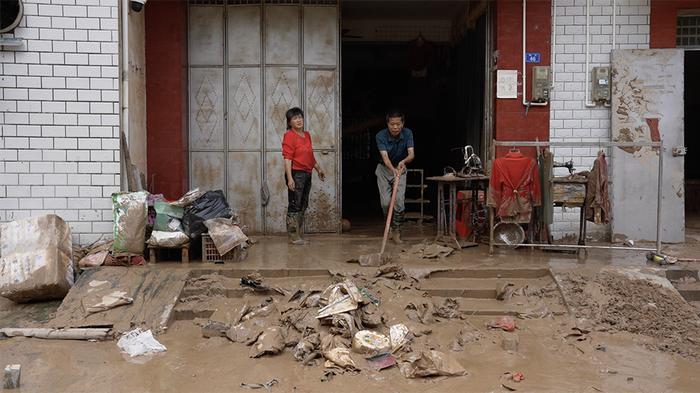村民清理家中泥水和杂物。