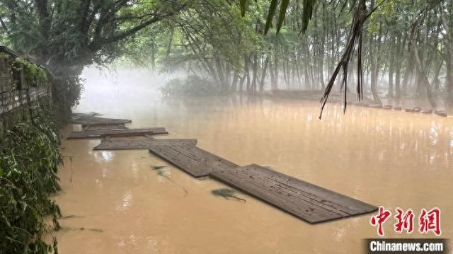 6月21日，西溪南村“网红桥”被洪水冲散，木质桥板散落在涨水后的丰乐河中。记者 赵强 摄