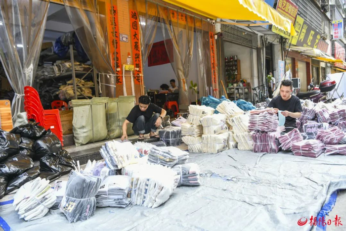 在上寮村的沿街商铺前，电商从业者正忙着检查货物、核对订单、安排出货。