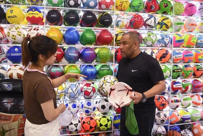 5月30日，义乌国际商贸城的商户（左）向埃及客商介绍足球产品。新华社记者黄宗治摄