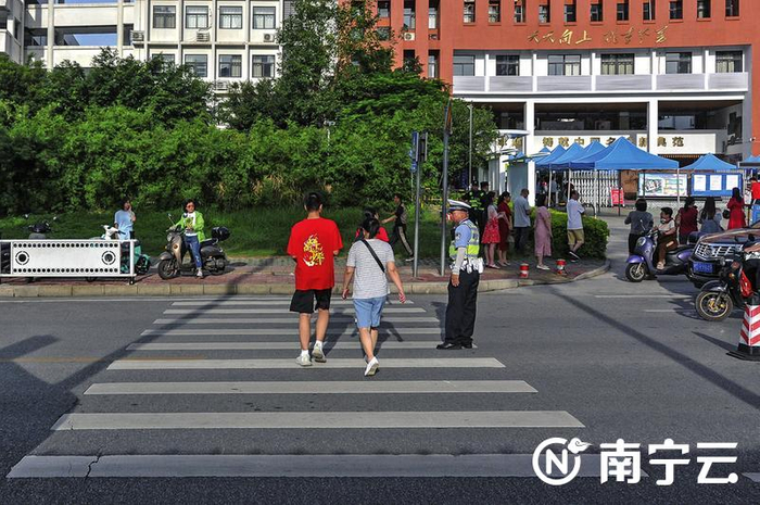 在天桃实验学校翠竹校区考点前，交警疏导过往车辆，保护考生安全走过斑马线。记者 黄维业 摄