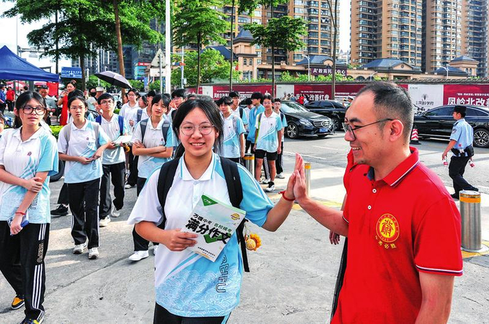 在南宁市天桃实验学校翠竹校区考点，带队老师与考生击掌，为考生加油鼓劲。本报记者黄维业 摄