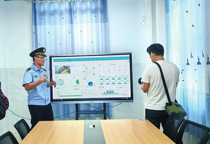 市场监管部门工作人员向媒体记者介绍学校食堂“互联网+明厨亮灶”系统。 本报记者杨玲 摄