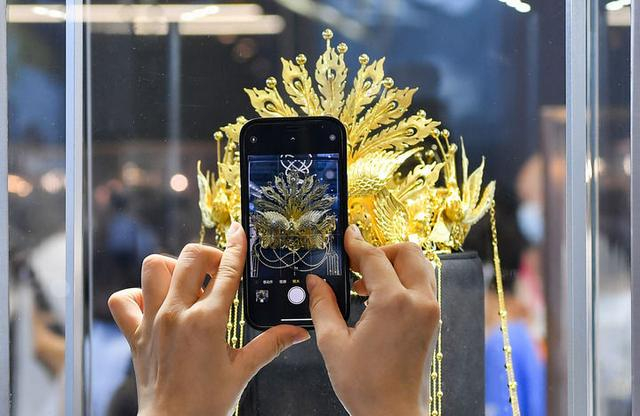 2022年7月29日，观众在消博会上拍摄老凤祥展出的“凤舞九天·金凤冠”。新华社记者 杨冠宇 摄
