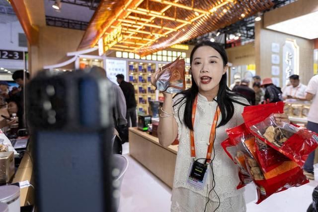 2024年5月13日，在上海举办的中国品牌博览会上，一名工作人员在中华老字号“新宝堂”展位直播带货。新华社记者 王翔 摄
