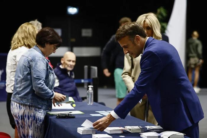 ▲6月30日，法国总统马克龙在法国北部的勒图凯－巴黎普拉日投票前领取选票。图源：外媒