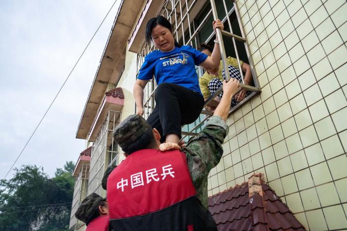7月1日,在平江县天岳街道大西村,民兵在转移群众。新华社记者 陈思汗 摄