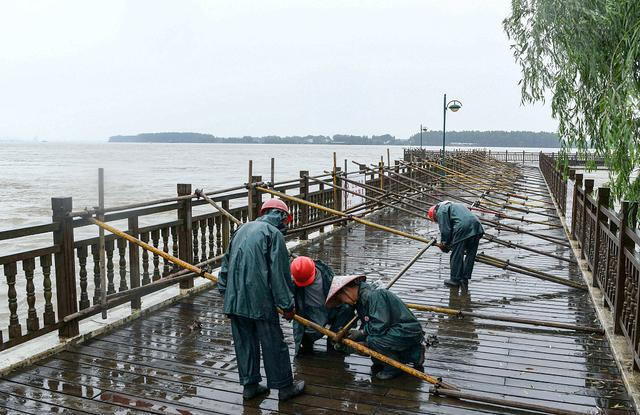 2024年6月29日，长江安徽铜陵段水位持续上涨，工人在冒雨加固铜陵滨江生态公园的江边设施。视觉中国 图