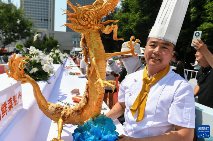 6月29日，参赛选手展示自己制作完成的锅包肉。（新华网）