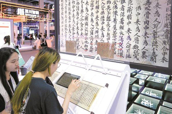 参展者在合合信息展位尝试敦煌遗书合成样本的文字修复，亲身体验AI古籍修复模型 本报记者  陈梦泽  摄