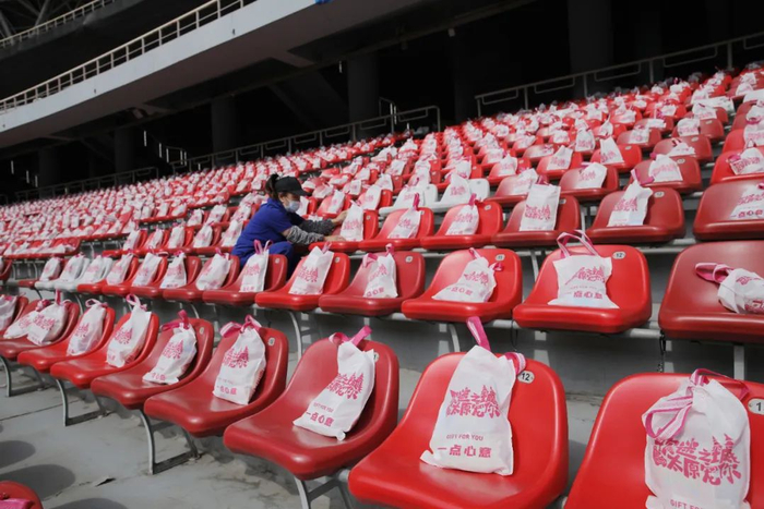 志愿者为歌迷摆上伴手礼。   王韵菲 摄