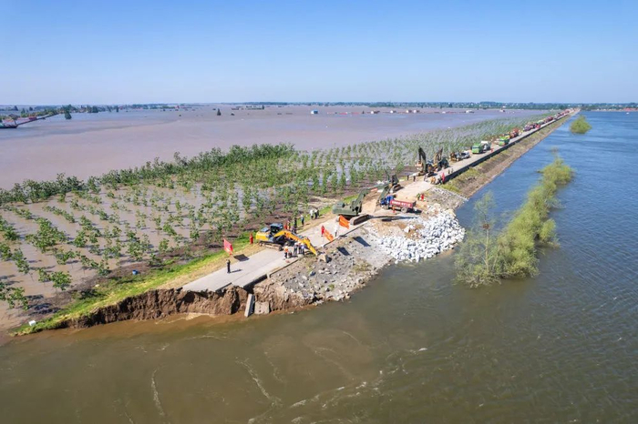 ▲7月6日，湖南省岳阳市华容县团洲垸，抢险人员卸载砂石尝试封堵决口（无人机照片）。图源新华社