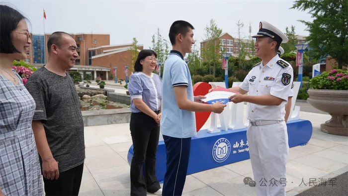 海军招飞办工作人员为尹子涵发放录取通知书。