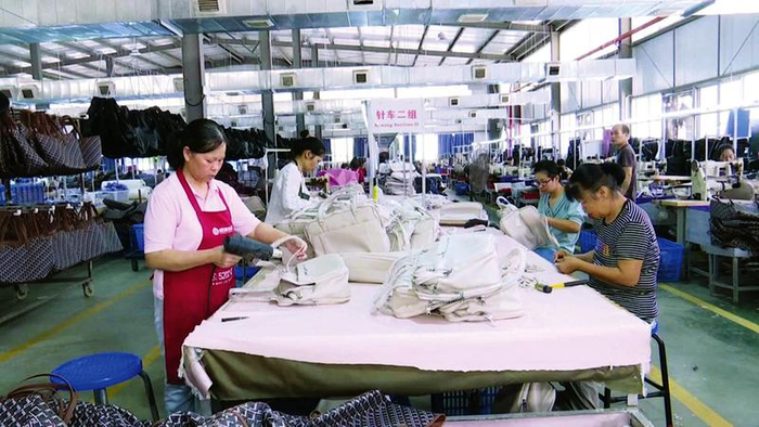 安置户在南宁市中禾箱包有限公司的生产车间忙于生产。（桂林银行供图）