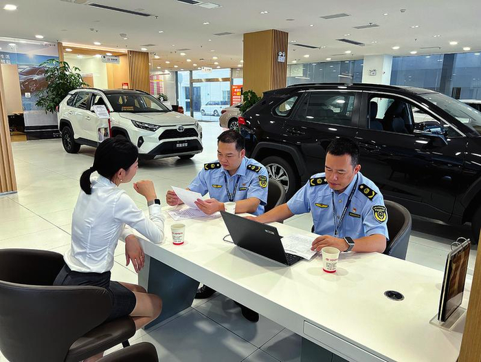 南宁市市场监管局专业市场分局执法人员在一家汽车4S店检查。（南宁市市场监管局专业市场分局供图）
