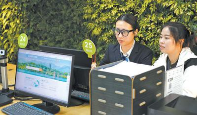 在浙江台州市黄岩区政务服务中心网办区，工作人员协助市民通过“浙里办”办理业务。章勇涛摄