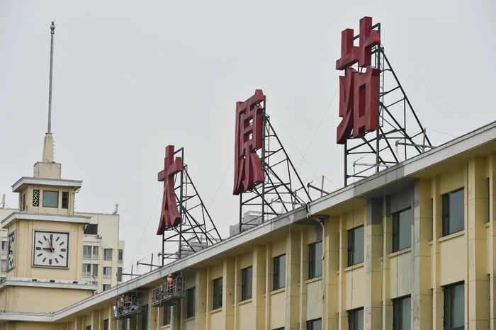 7月16日,施工人员正在吊篮里对太原火车站的外立面进行作业,作为太原