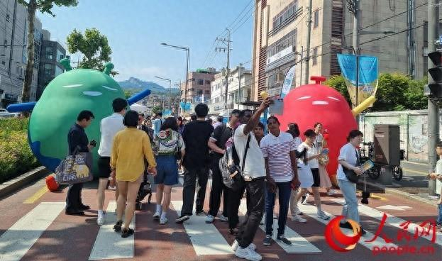 访韩外国游客参加韩国当地美食节活动。 人民网 李帆摄