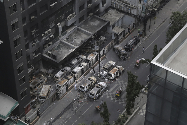 2024年7月21日，孟加拉国达卡，在反对“配额制”的抗议中，烧毁的车辆和一座被大火损坏的建筑。视觉中国 资料图