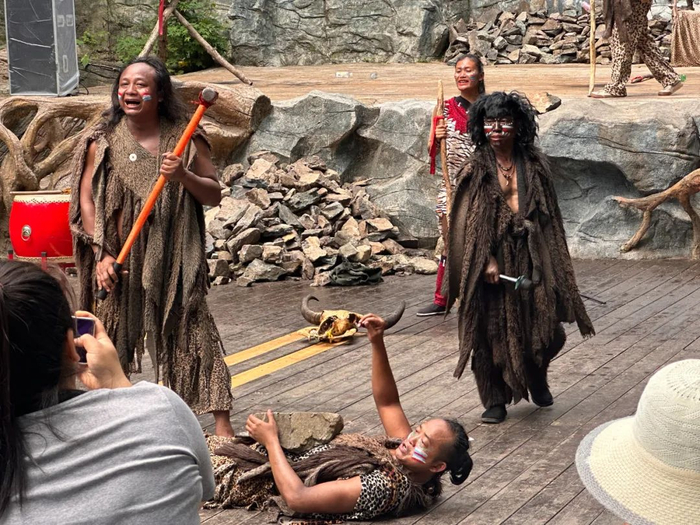 ▲野人谷上方的舞台上，演员们在表演胸口碎大石。（图/新周刊 摄）