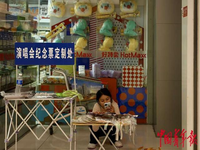 7月19日，北京，新奥购物中心，一名摊主用折叠桌支起摊位，等待客人光顾。林小渠/摄