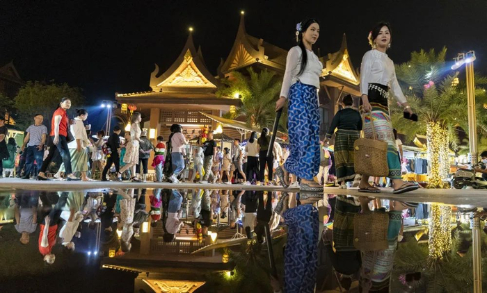 2023年4月11日，身着少数民族服饰的游客在云南芒市傣族古镇内游玩（陈欣波/摄）