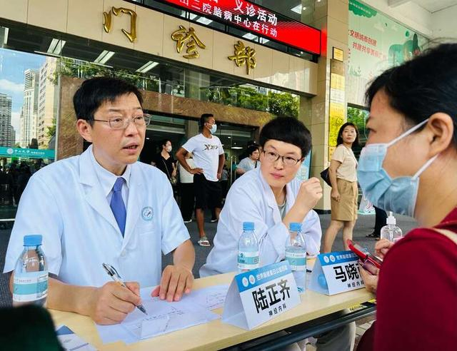 中山三院神经内科主任陆正齐（左一）正给患者咨询。中青报·中青网记者 林洁/摄