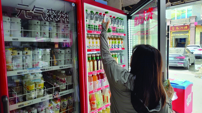 图为消费者正在选购瓶装饮用水。