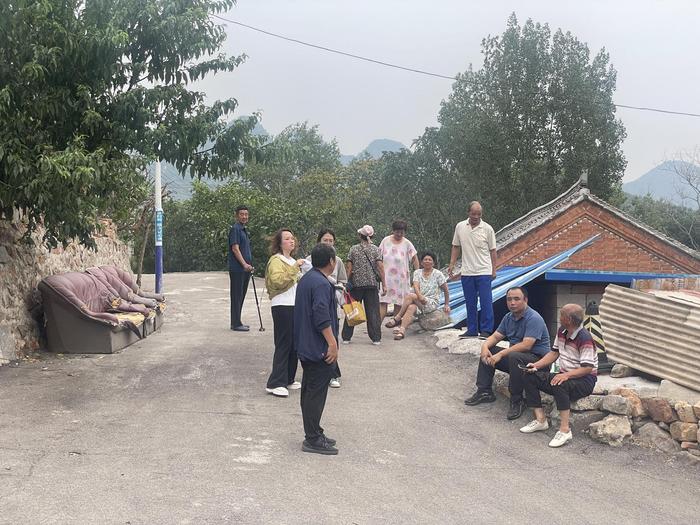 村民们在村东头等转送车辆。新京报记者 赵利新 摄