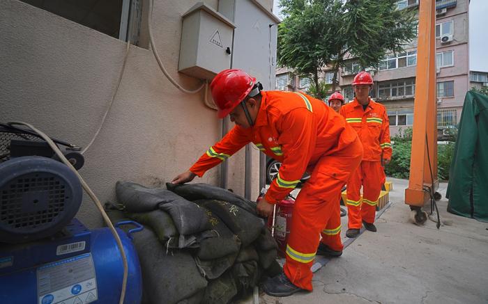 国网北京丰台供电公司应急救援人员为应对暴雨天气，提前集结完毕，做好防汛沙袋及排水设备准备工作，确保电网稳定运行。张涛 摄