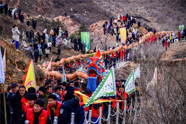 志愿者们手举6500米羊绒彩龙，沿着红山国家森林公园景观步道巡游。