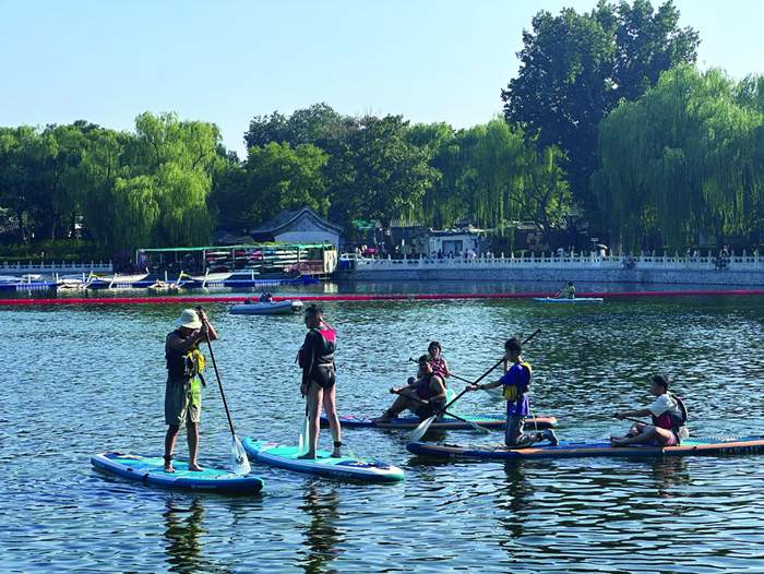 图为在什刹海体验桨板运动的爱好者。李芸仪 摄