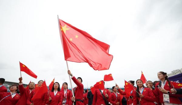 当地时间7月26日，中国体育代表团旗手乒乓球选手马龙（中）在开幕式前挥舞国旗。新华社记者 曹灿 摄