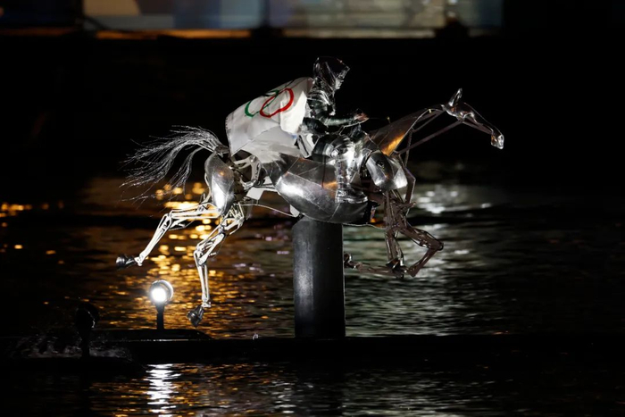 7月26日，女骑手弗洛里亚娜·伊塞尔手捧奥林匹克五环旗进入特罗卡德罗广场。新华社记者 费茂华 摄