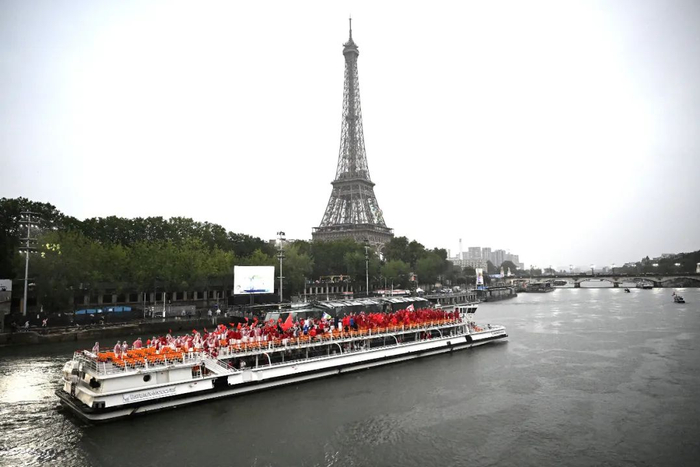 7月26日，中国体育代表团乘坐的船只行驶在塞纳河上，远处是埃菲尔铁塔。新华社记者 李安 摄