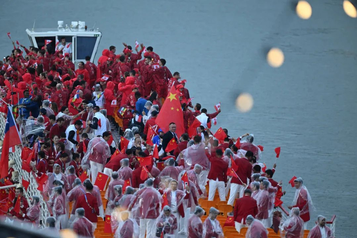 7月26日，中国体育代表团成员（前）在开幕式上。新华社记者 胡虎虎 摄