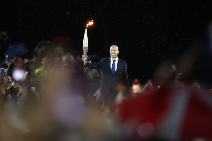 7月26日，法国足球名宿齐达内手持奥运火炬传递。新华社发（POOL照片/卡梅伦·斯潘塞）