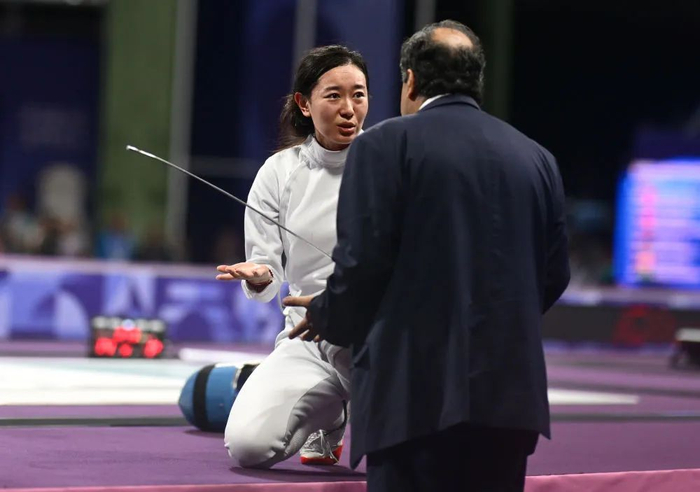 ▲7月27日，孙一文（左）在比赛中与裁判交流。新华社记者 张宏祥 摄