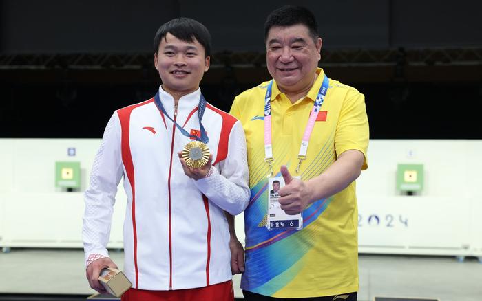 谢瑜（左）夺冠后和国际射联副主席、中国射击奥运冠军王义夫合影。 图/新华社