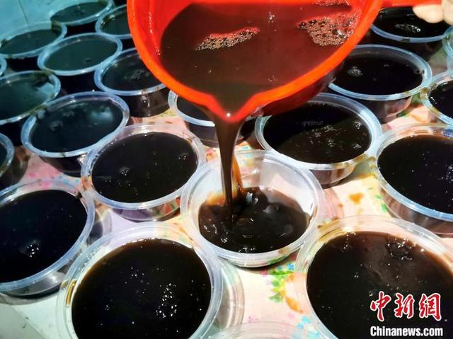 7月25日凌晨，广东台山市，刚煮好滤渣后的茯苓膏被逐一分装。李晓春 摄